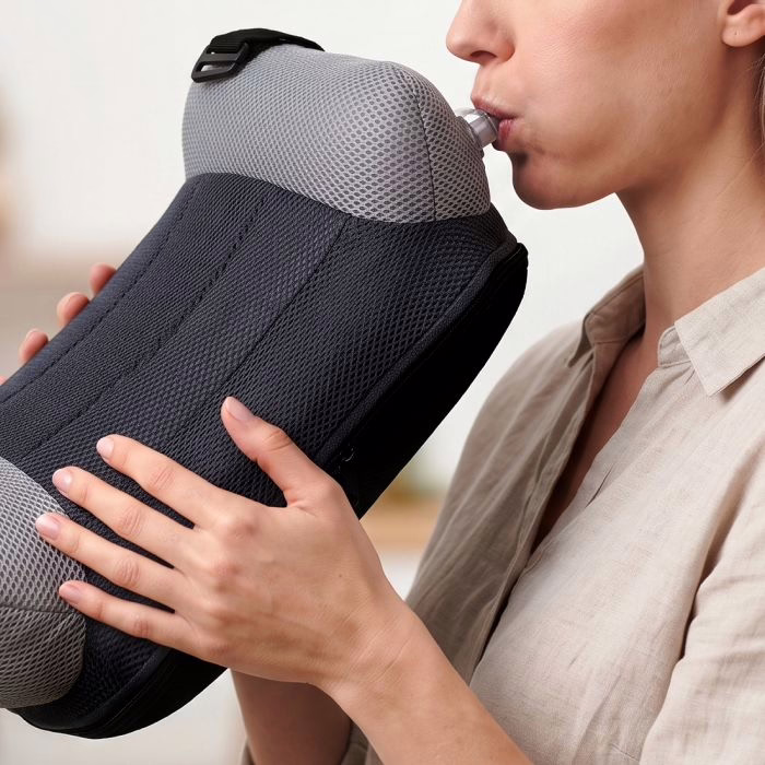 Deux mains tenant le rehausseur BubaBoost et gonflant la chambre à air par la valve